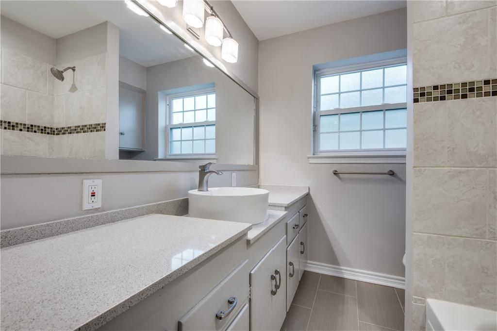 A bathroom with two sinks and a large mirror