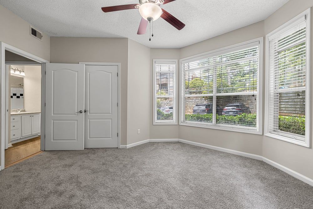 an empty room with a ceiling fan and a lot of windows at Marquis Midtown West in Atlanta, GA.