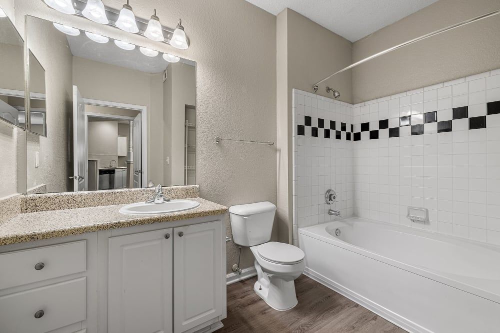 a bathroom with a toilet, sink, and bathtub at Marquis Midtown West in Atlanta, GA.