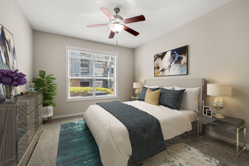 a bedroom with a bed, dresser, nightstand, and ceiling fan at Marquis Midtown West in Atlanta, GA.