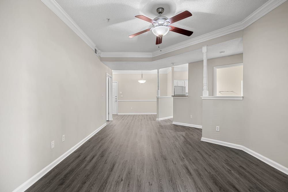 an empty living room with hardwood floors and a ceiling fan at Marquis Midtown West in Atlanta, GA.