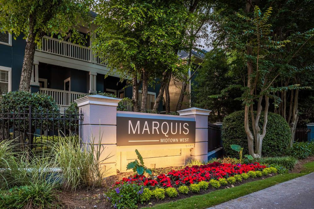 a sign for marquis apartments is lit up in front of a building at Marquis Midtown West in Atlanta, GA.