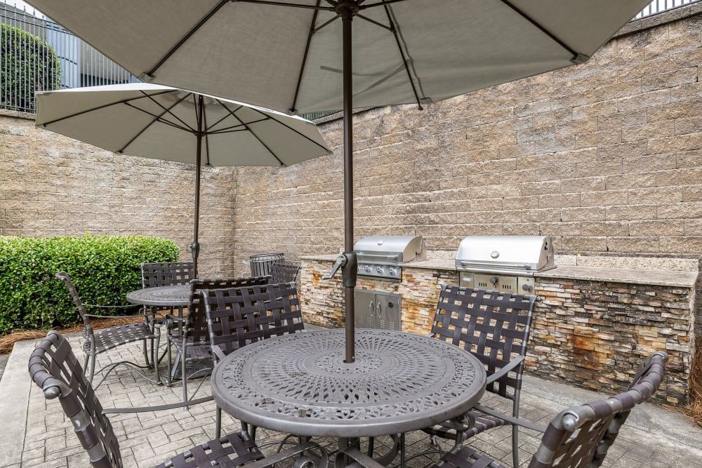 a patio with a table and chairs and umbrellas at Marquis Midtown West in Atlanta, GA.