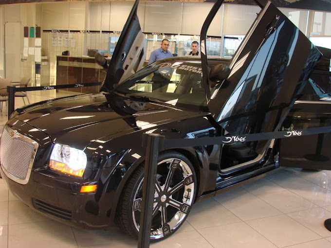 A black chrysler car with its doors open