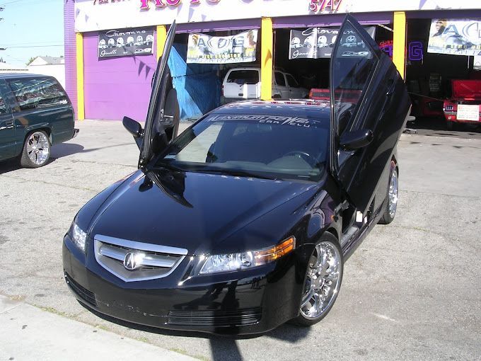 A black car is parked in front of a purple building