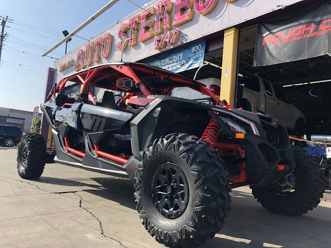 A red and black atv is parked in front of an auto store.