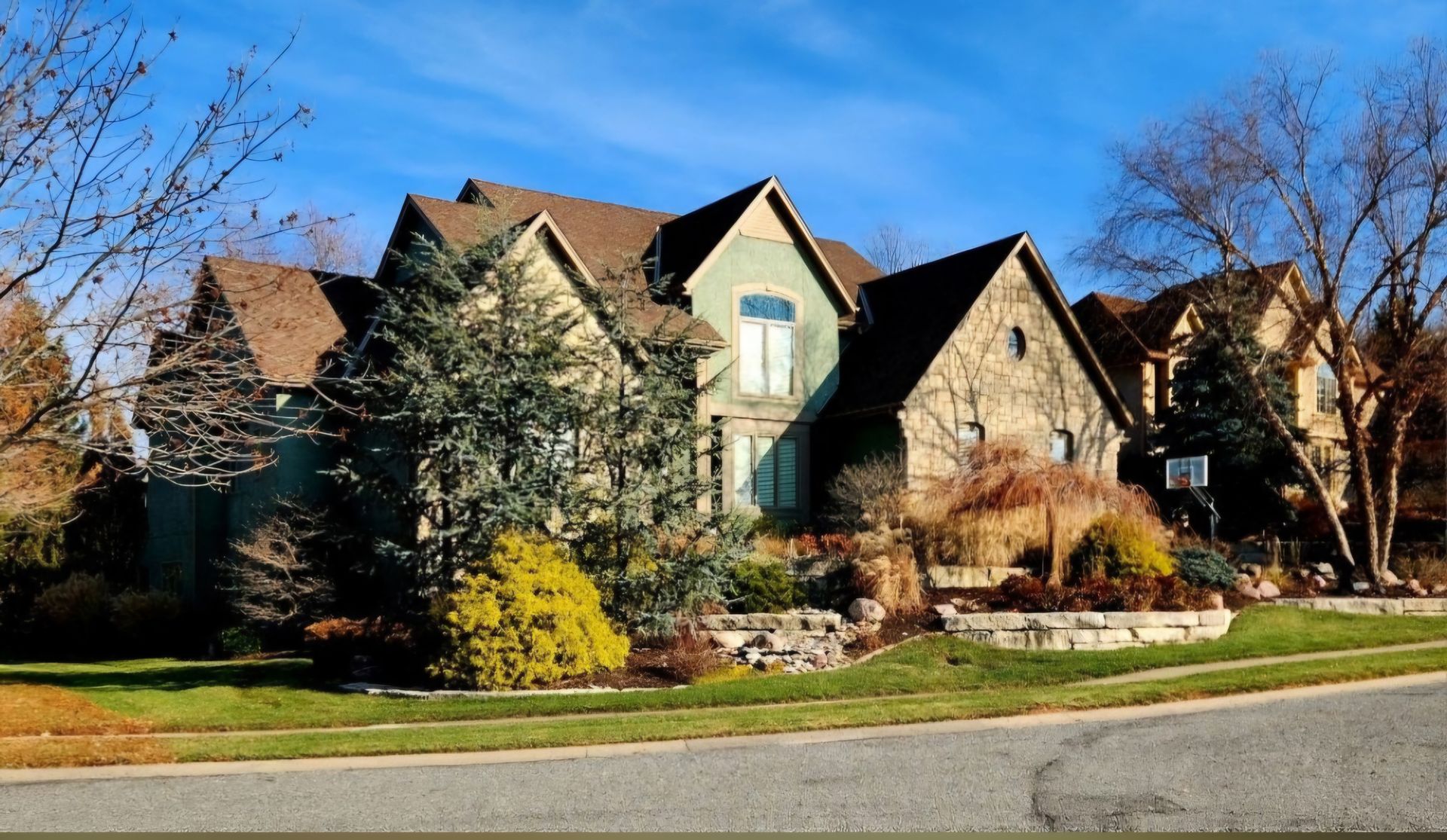 A large house sits on the corner of a residential street