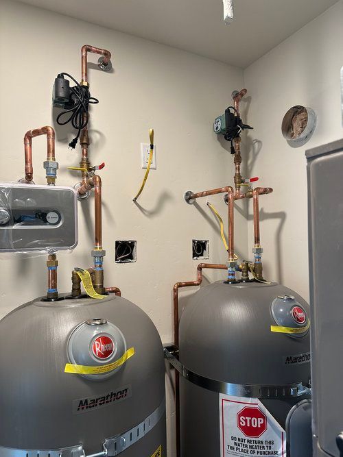 A room with copper pipes and a water heater.