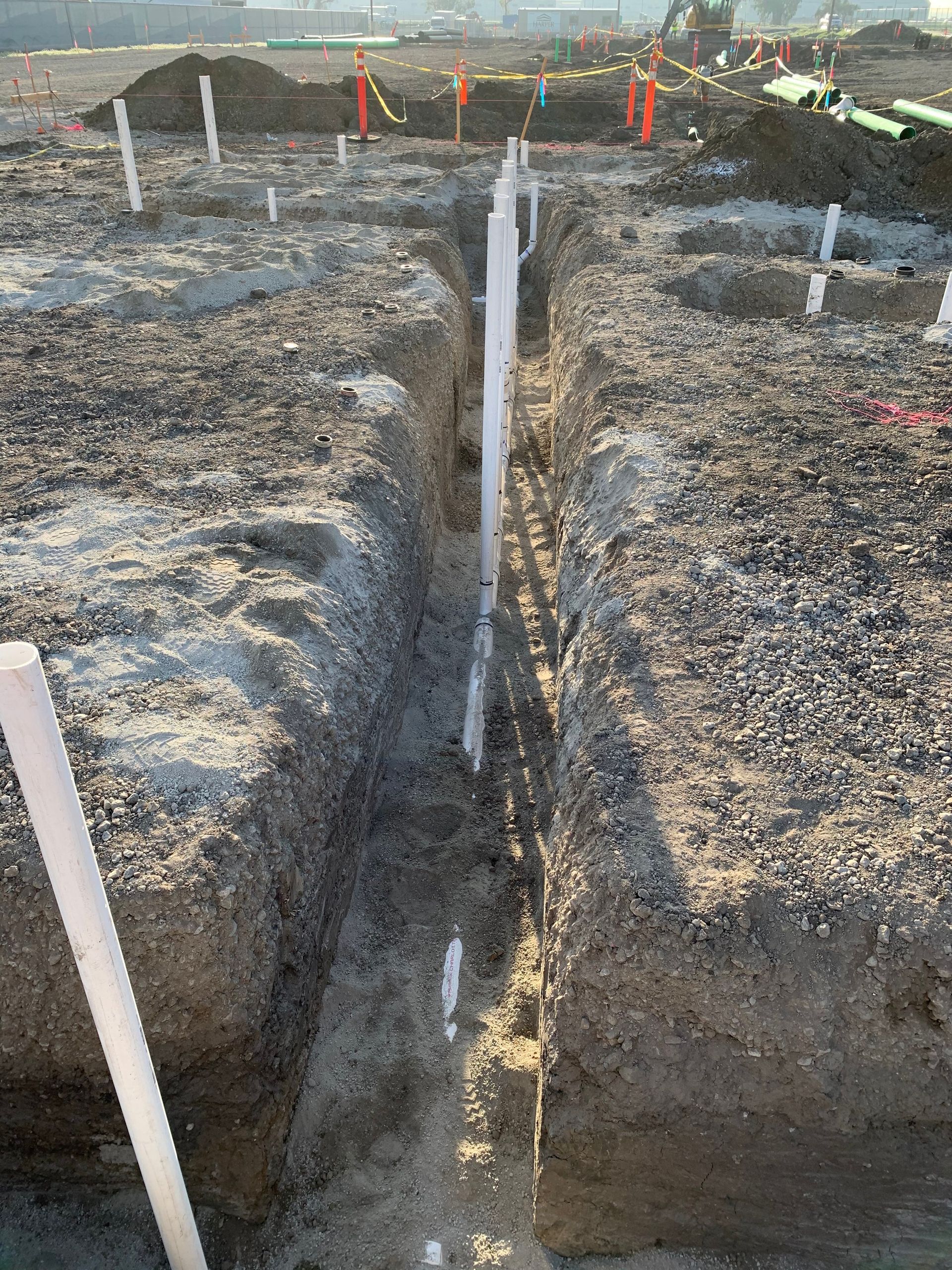 A trench with a white pipe in the middle of it