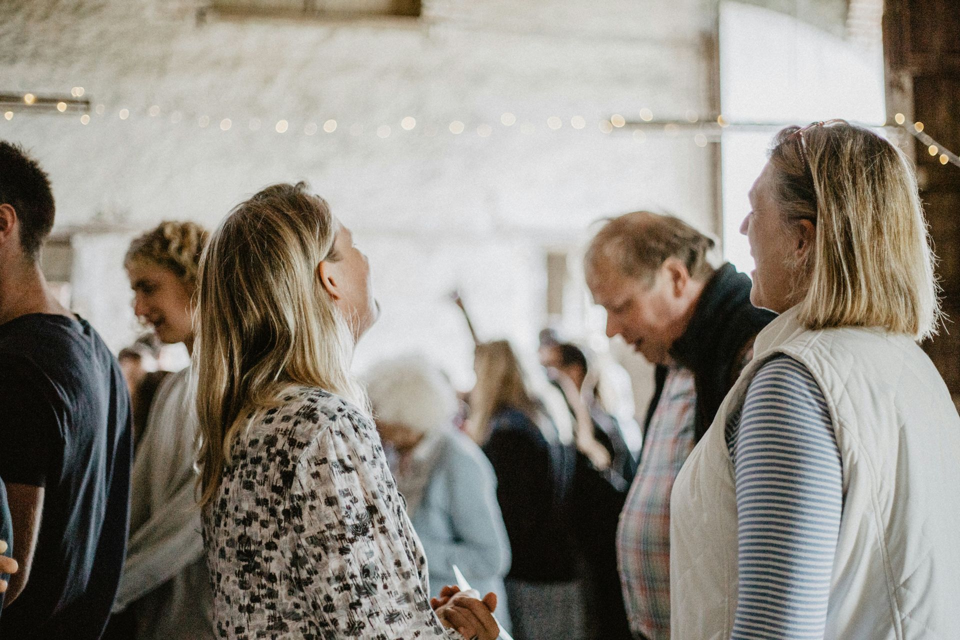 A group of people are standing in a room talking to each other.