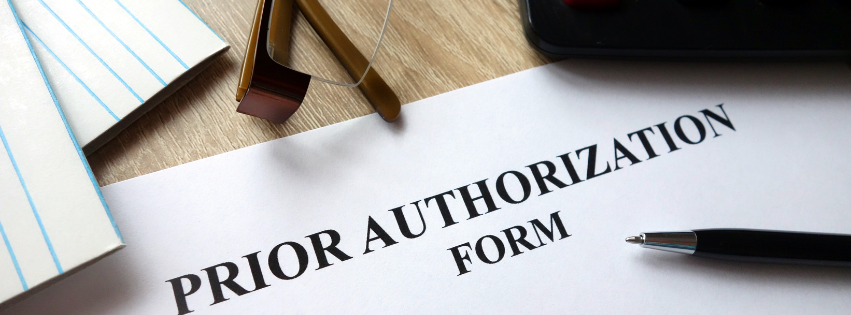 Prior Authorization Form on a desk, next to a pen and notepad.