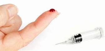 Finger with a drop of blood and a syringe, likely for blood sampling or injection, on a white background.