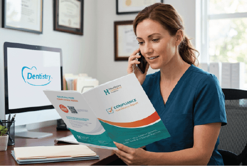 Female dentist looking at Free Compliance Risk Review while talking to a compliance expert on the phone.