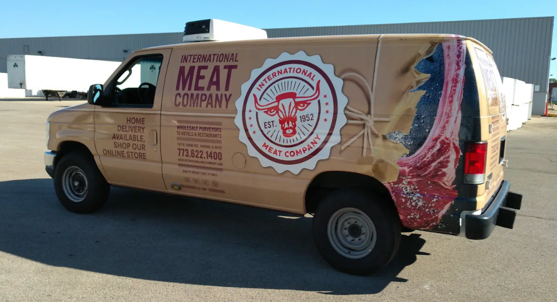 Tan International Meat Company van parked outside a warehouse. Branding features a steer head logo and meat graphic.