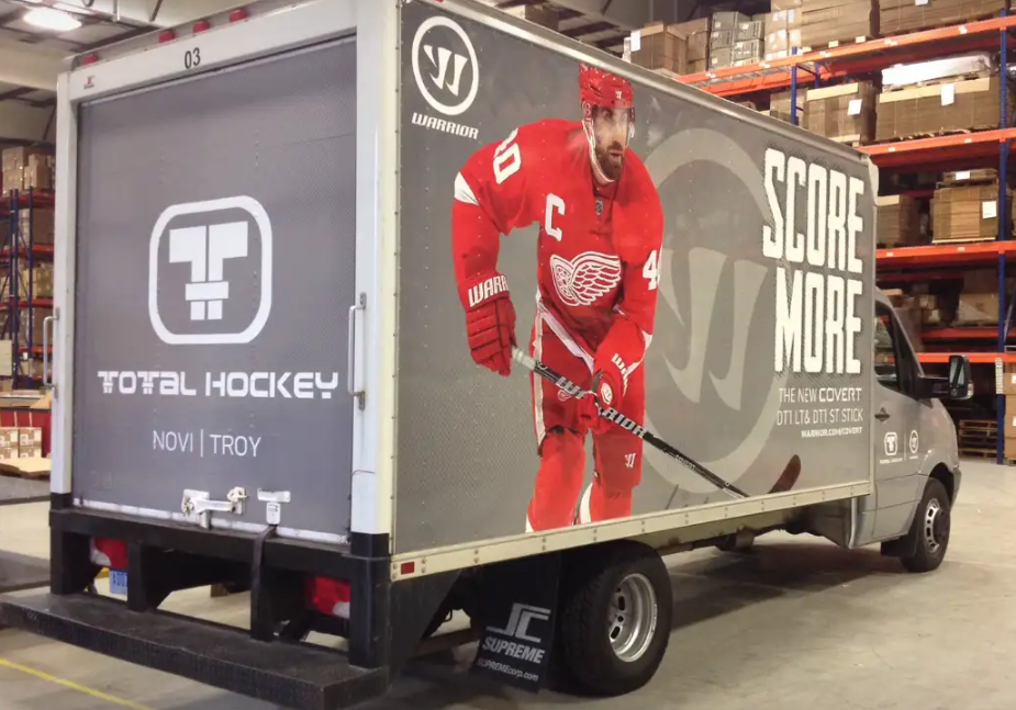 Box truck with Total Hockey logo and hockey player advertisement.