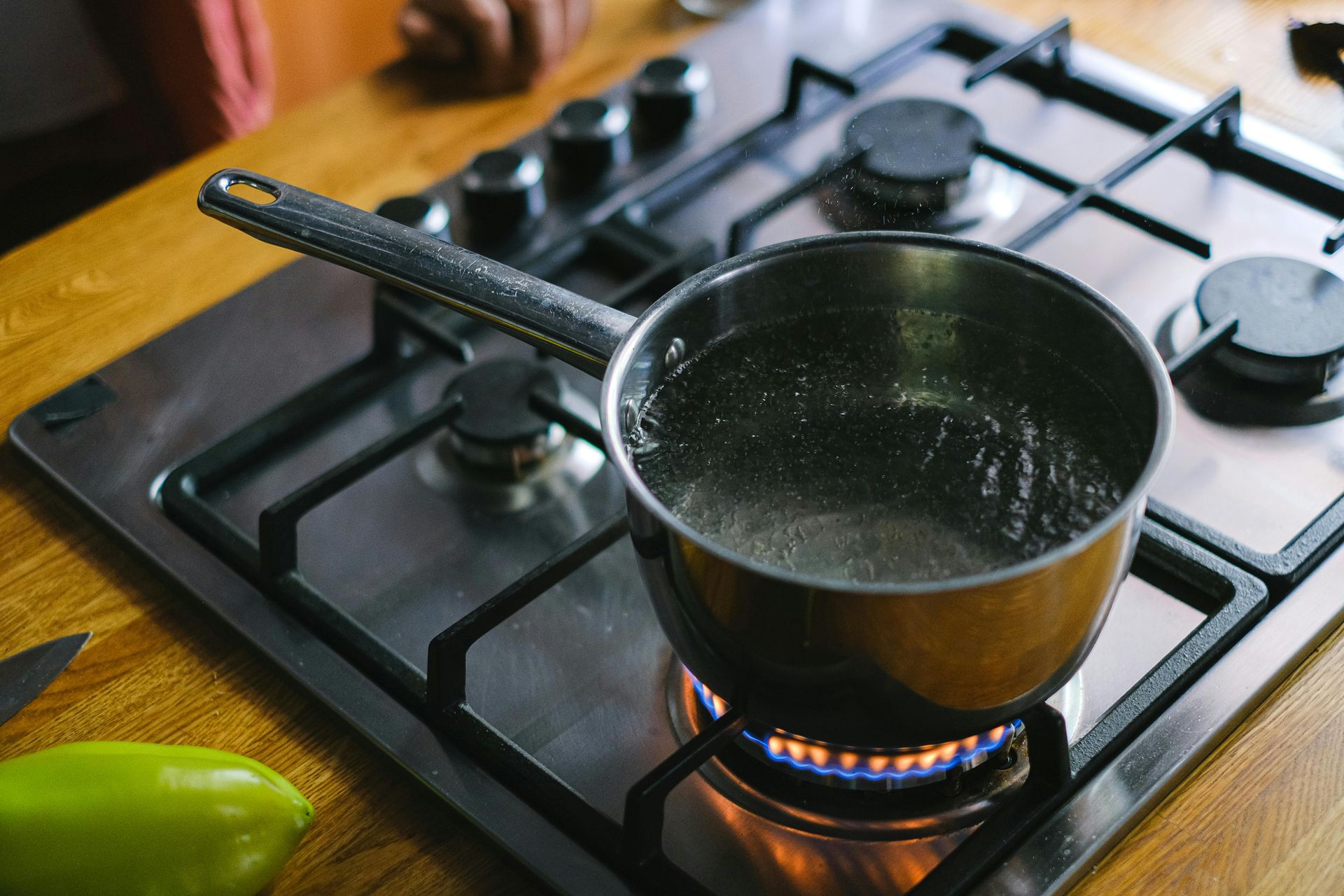 A pot of water is cooking on a gas stove. — Ashley Chick Plumbing In Baranduda, VIC