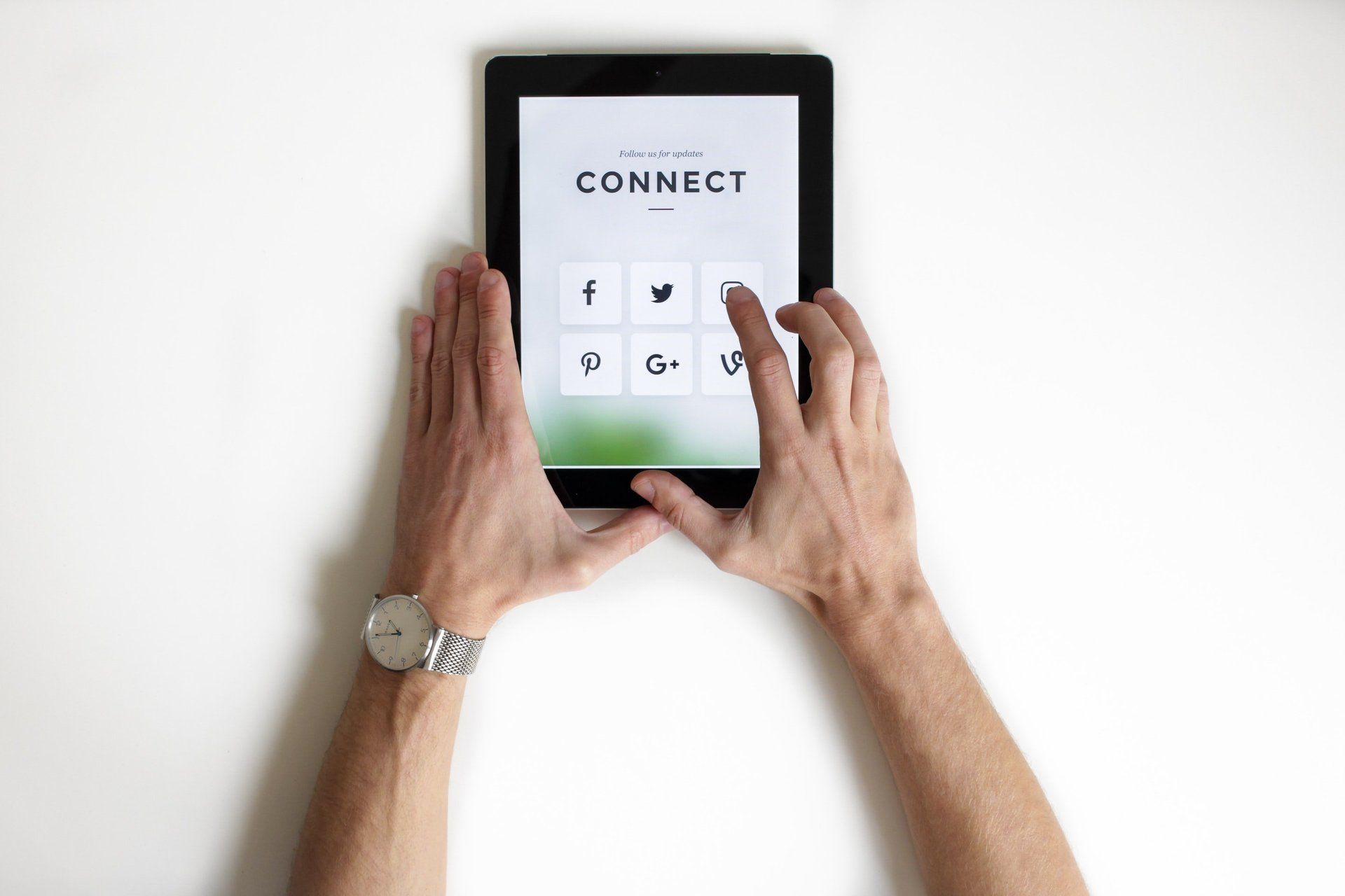 A person is holding a tablet with the word connect on the screen.