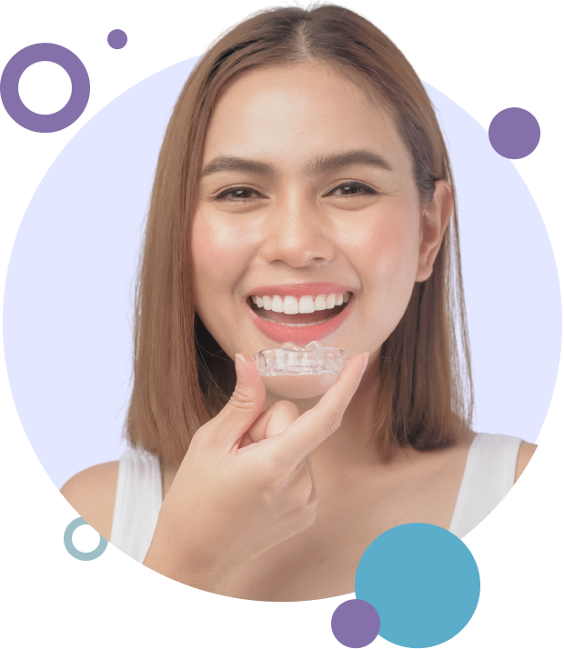 Woman holding an Invisalign clear aligner