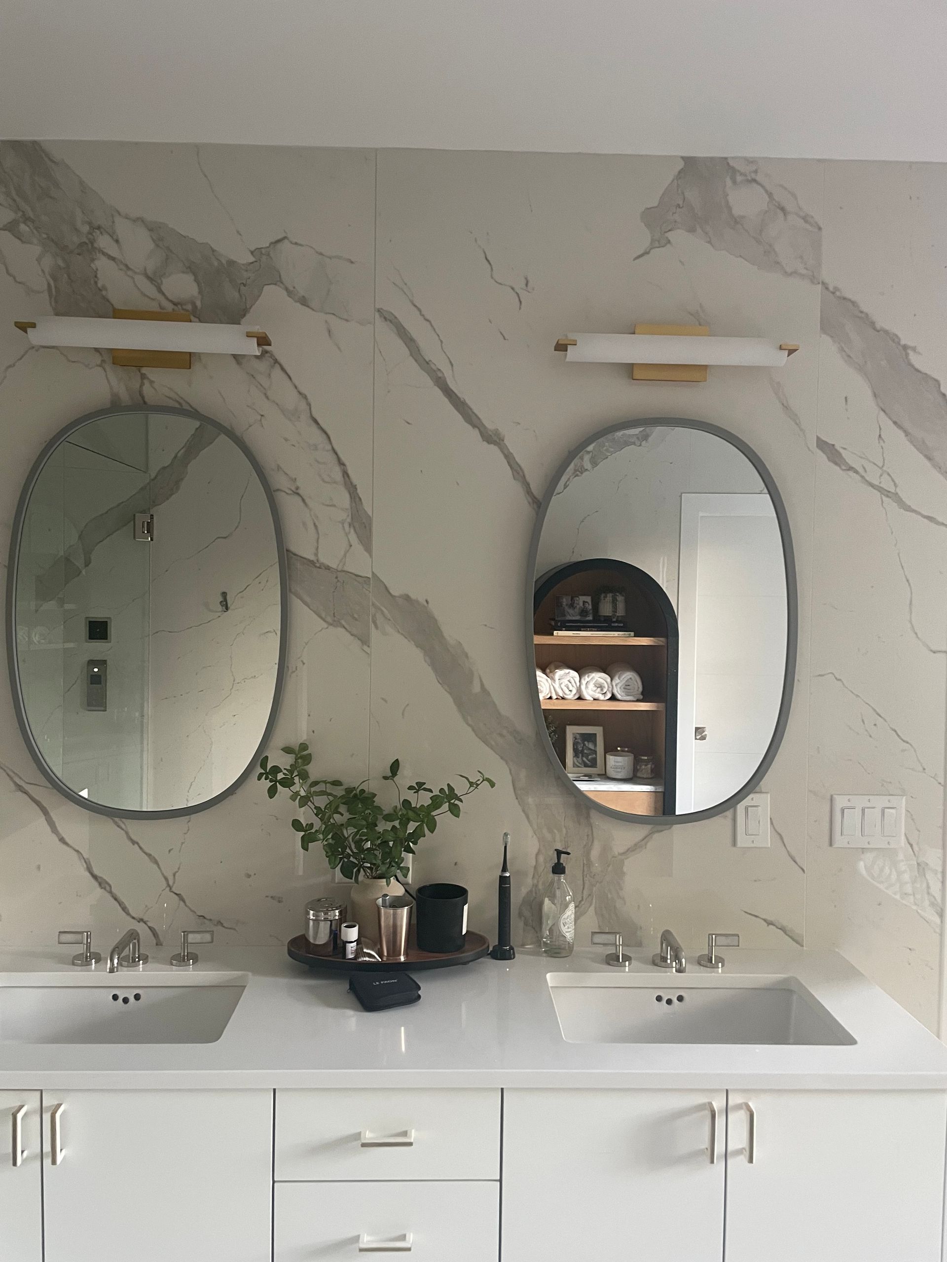 A bathroom with two sinks and two mirrors on the wall