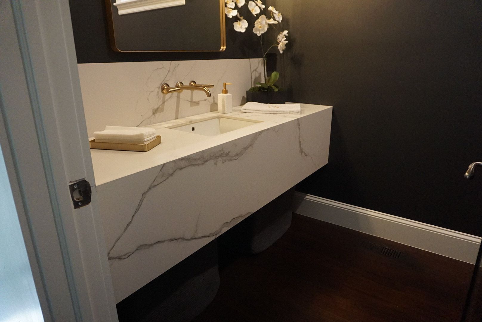A bathroom with a marble counter top and a sink.