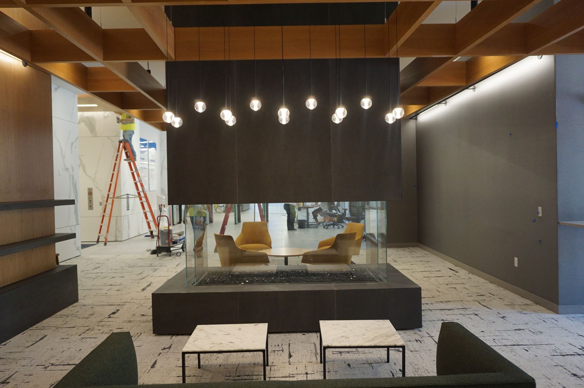A living room with a fireplace and chairs and tables