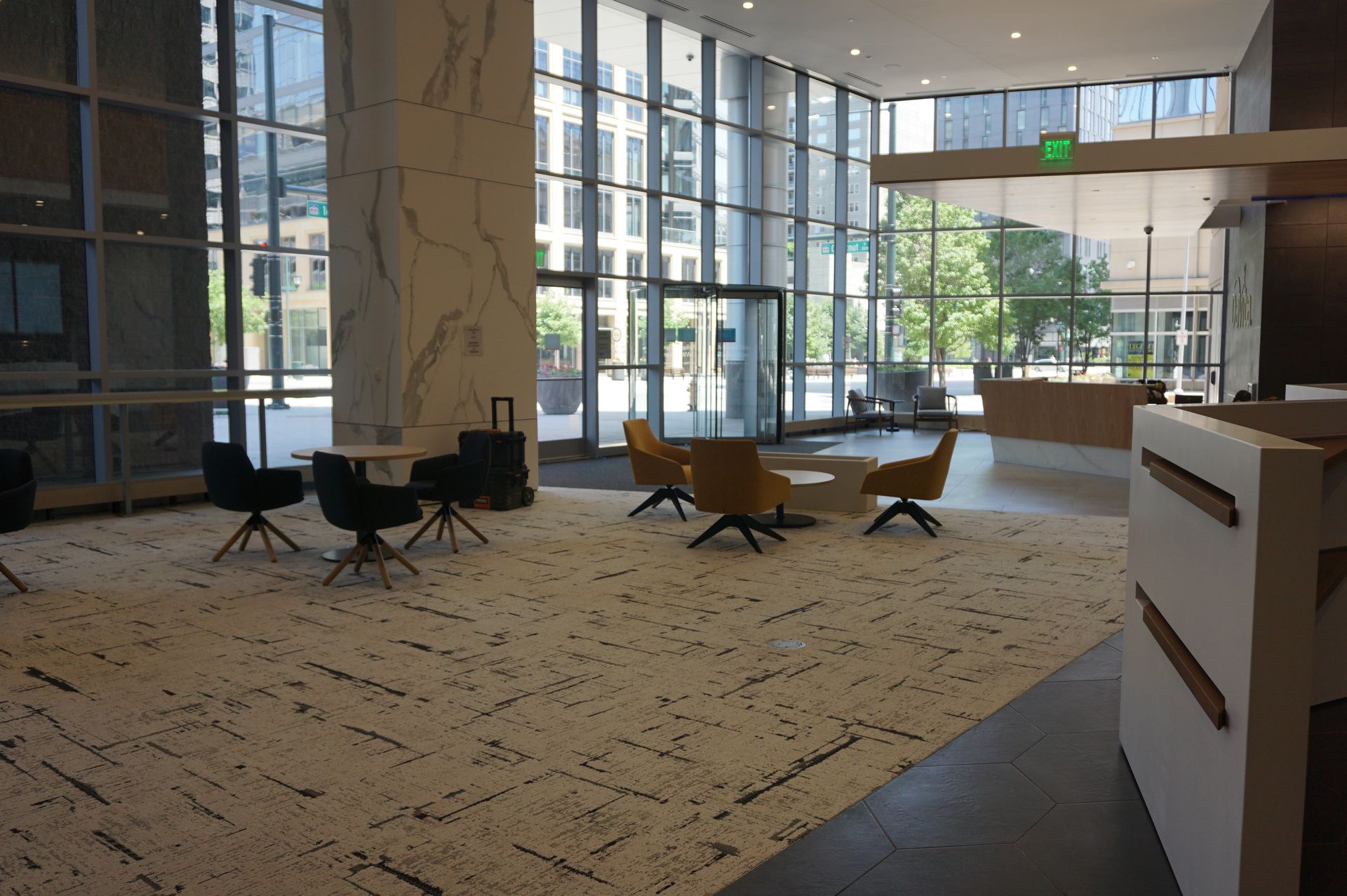 A large lobby with tables and chairs in a building.