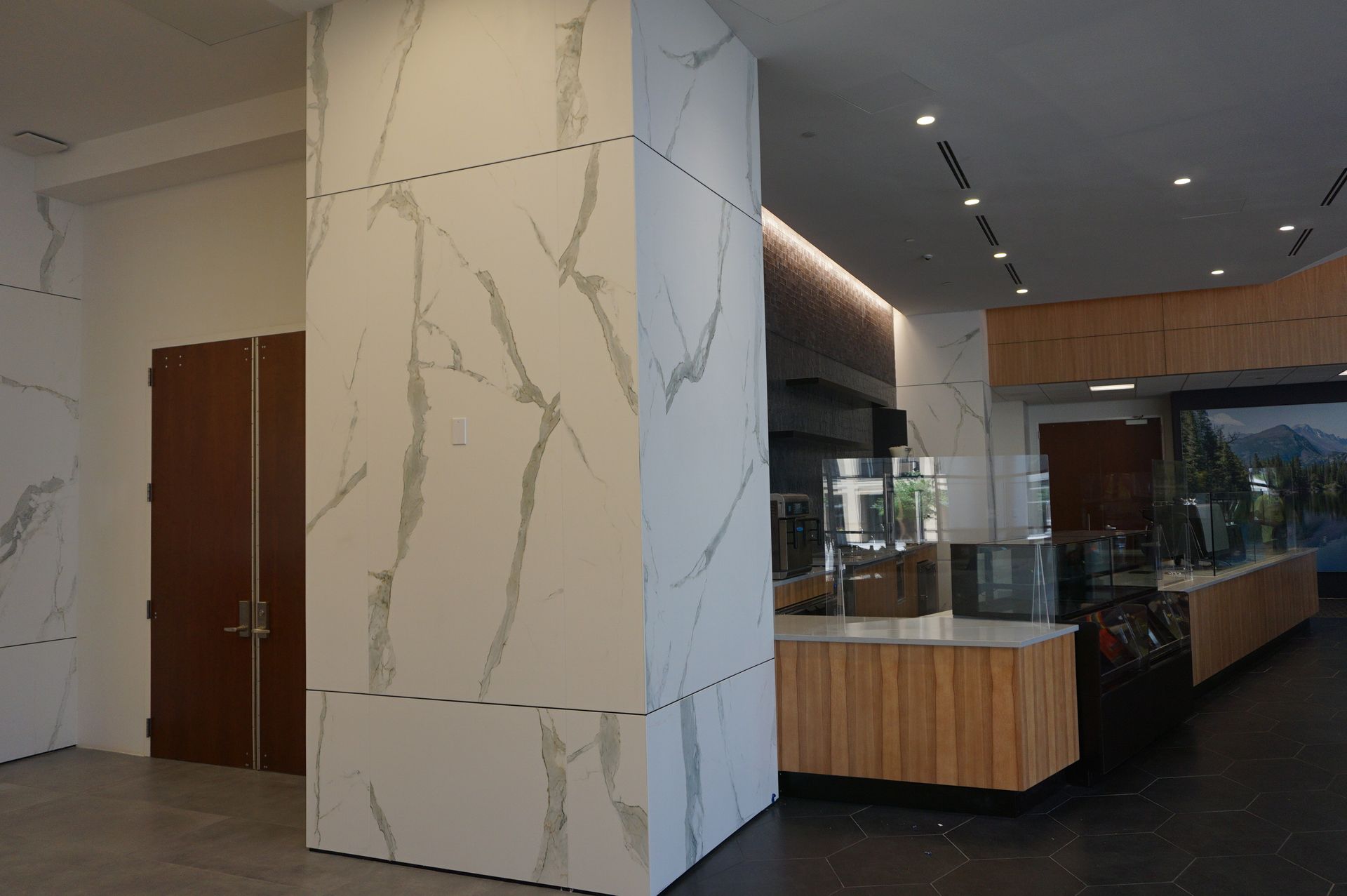 A restaurant with marble walls and a wooden counter.