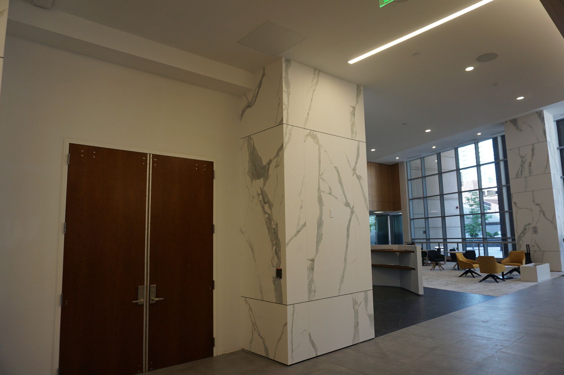 A large lobby with marble columns and wooden doors.