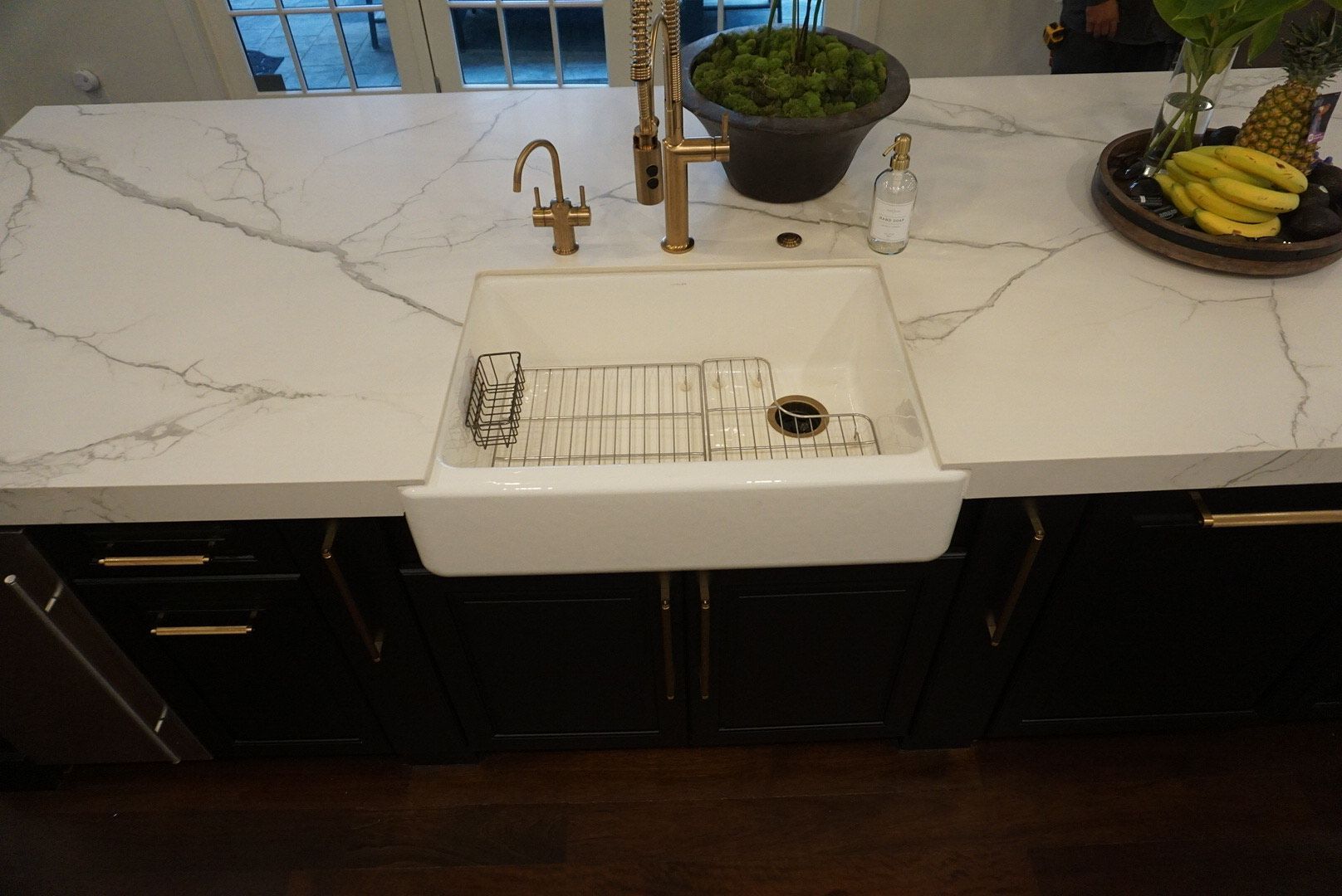 A kitchen sink with a soap dispenser on top of it.