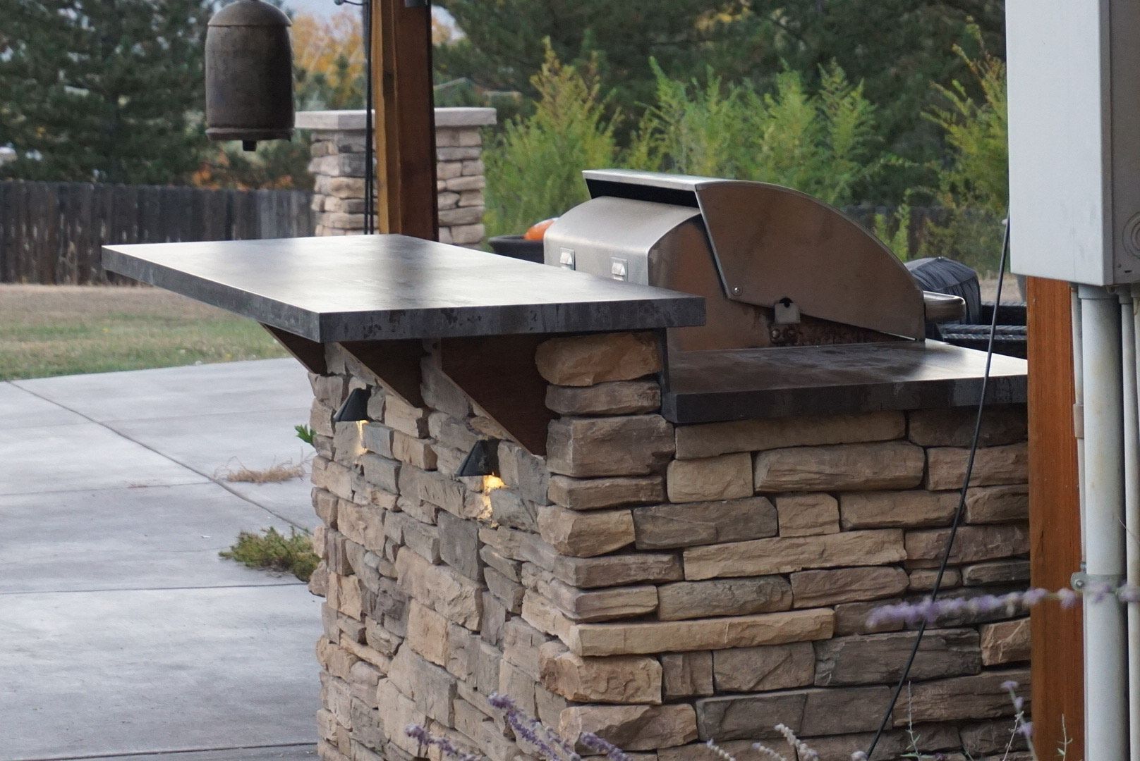 An outdoor kitchen with a grill and a counter top