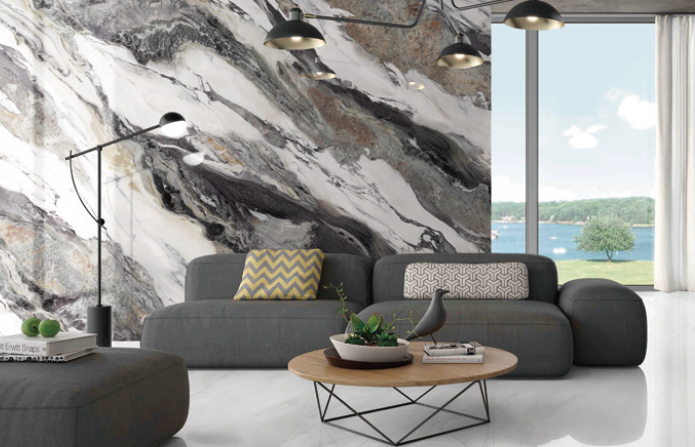 A living room with a couch , coffee table , and a large marble wall.