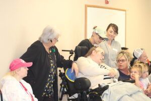A group of people are standing around a resident 