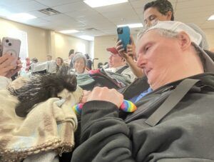 a porcupine is sitting on a residents lap at an event for the jimmy simpson foundation