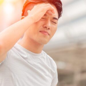 A man is holding his head because he has a headache.