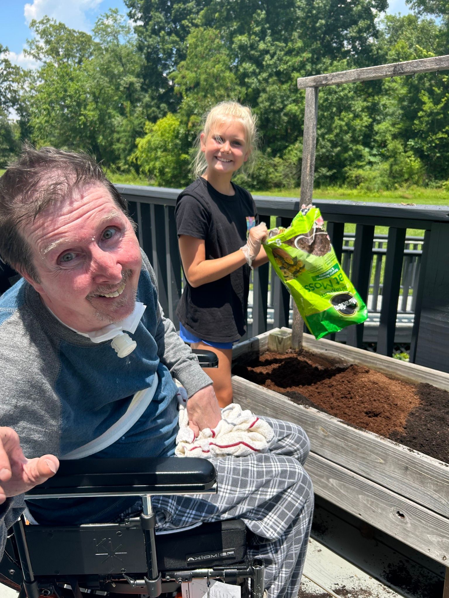 Brain injured man and female volunteer plant flowers.