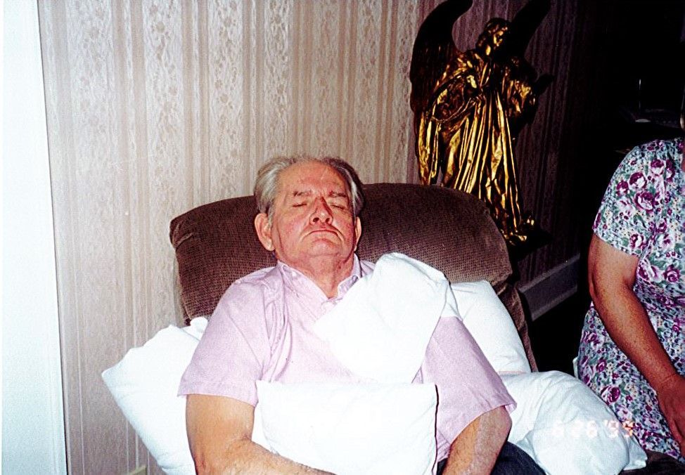 A man with a bandage on his arm is laying in a chair.