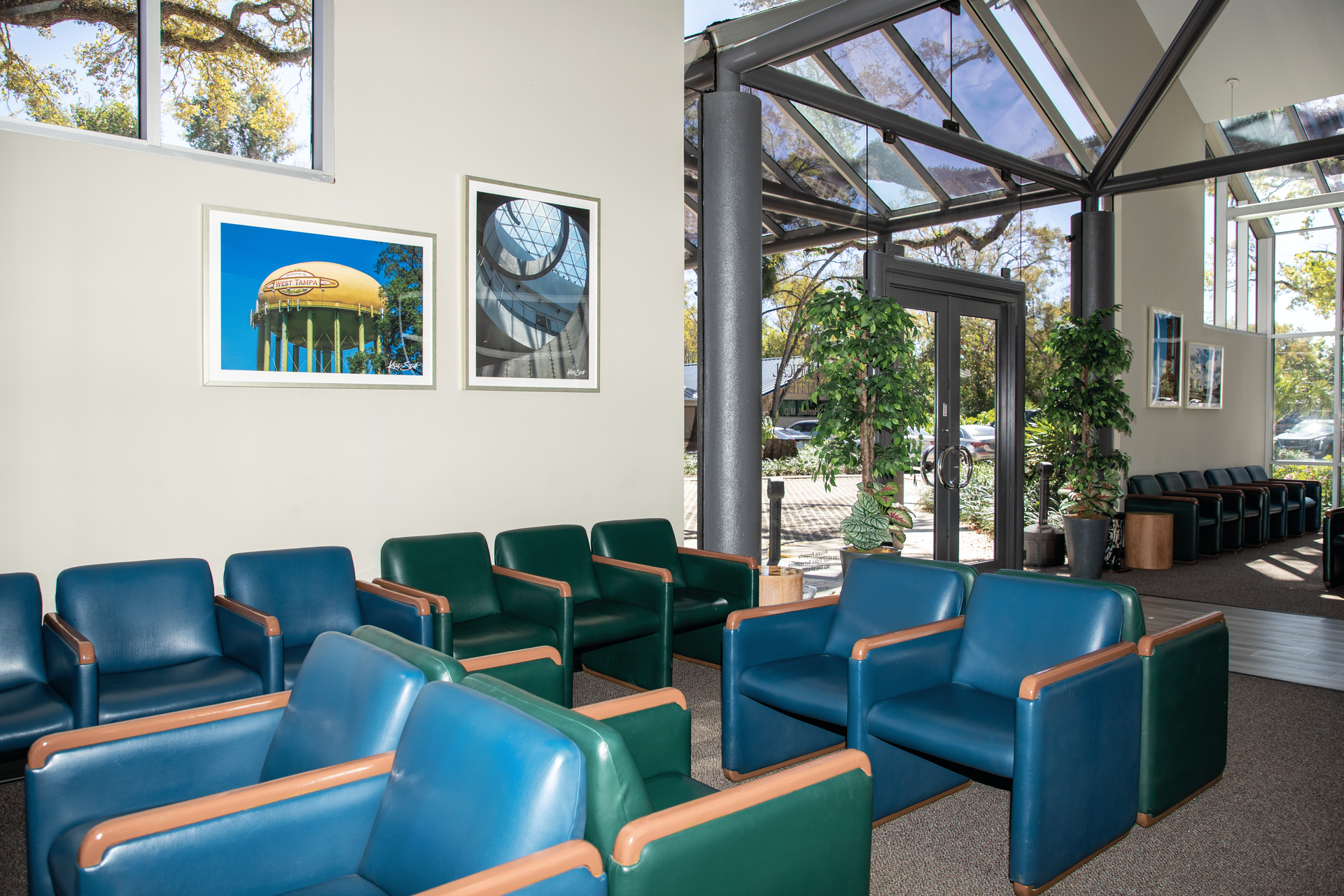 A waiting room with blue chairs and green chairs