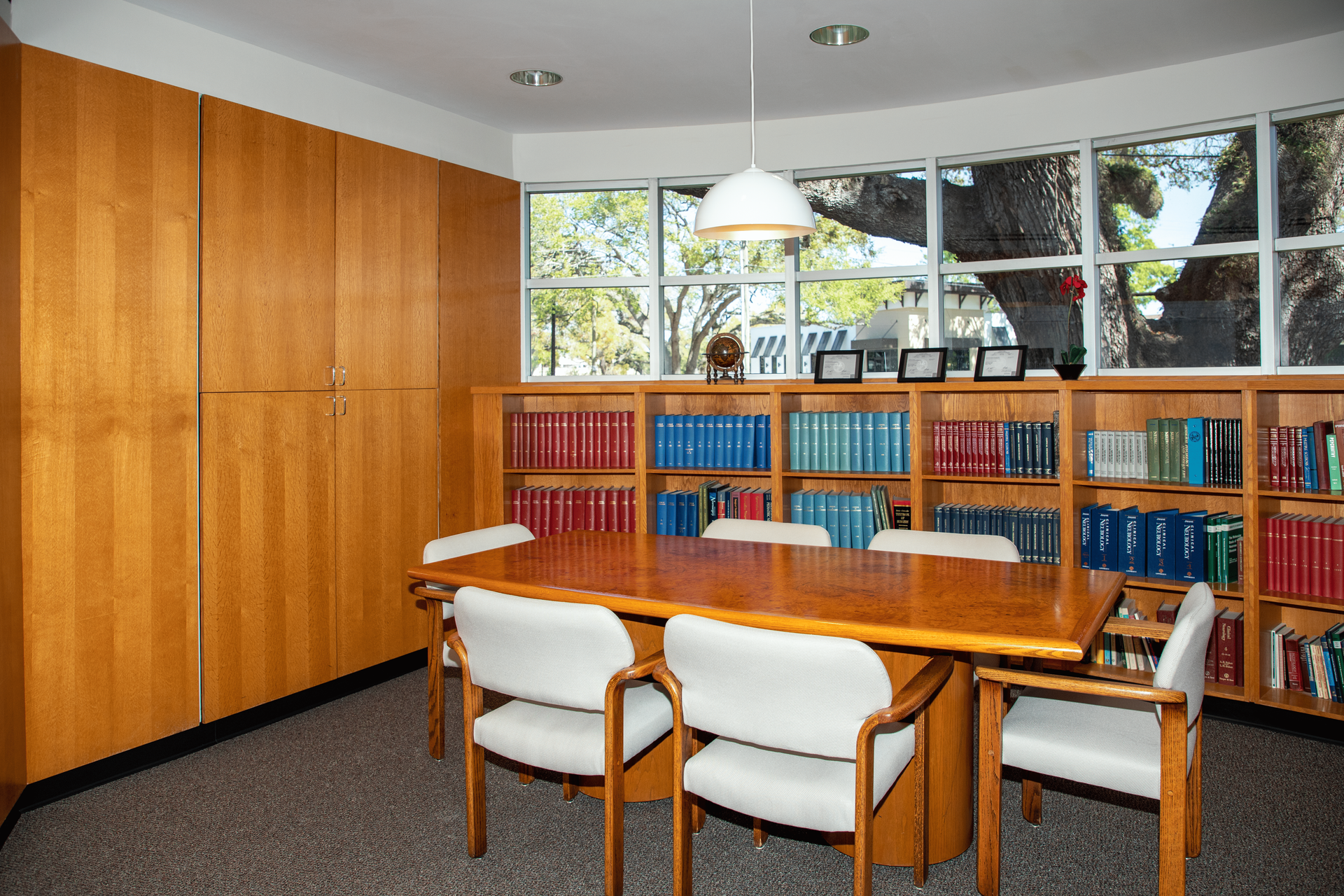 A library with a table and chairs and shelves full of books