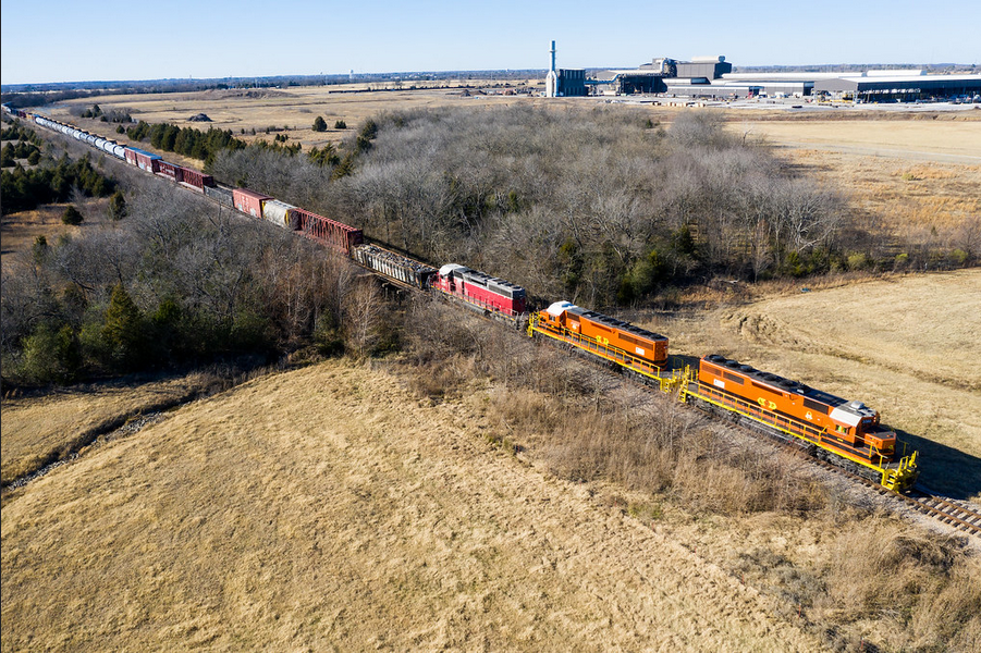 an aerial view of a train traveling down train tracks .