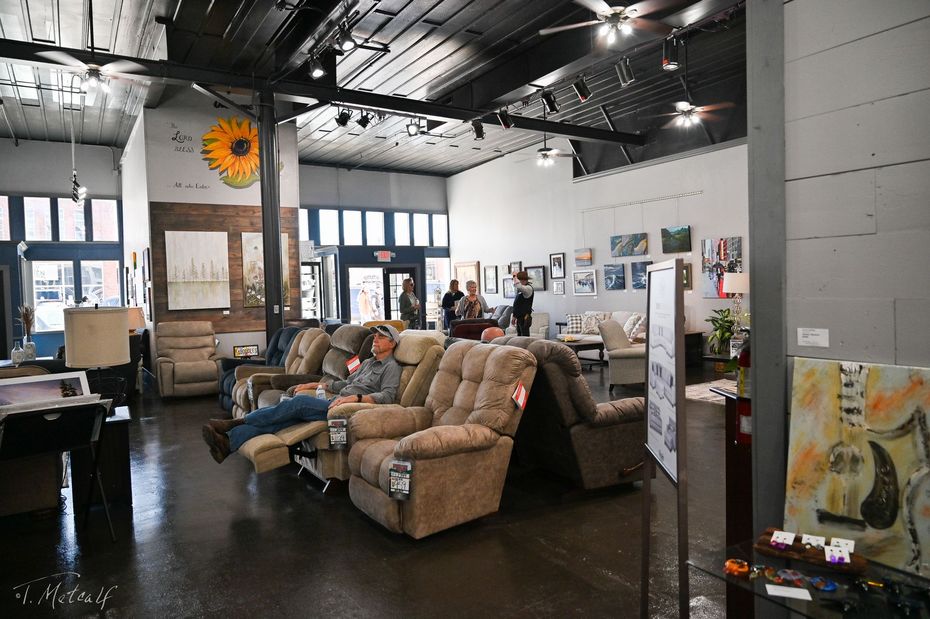 a group of people are sitting in recliner chairs in a large room .