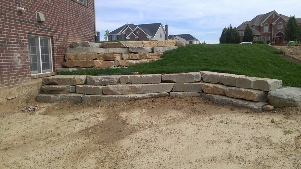 A brick house with a stone wall in front of it
