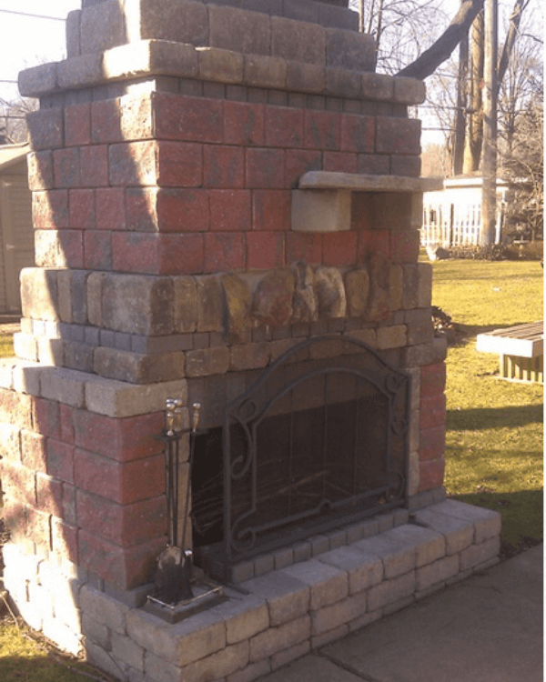 A brick fireplace with a shelf on top of it