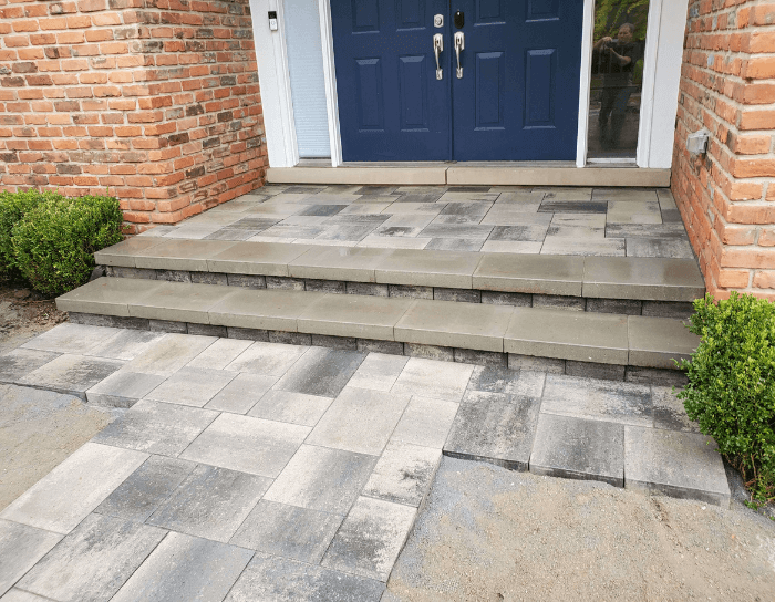 A brick house with a blue door and steps