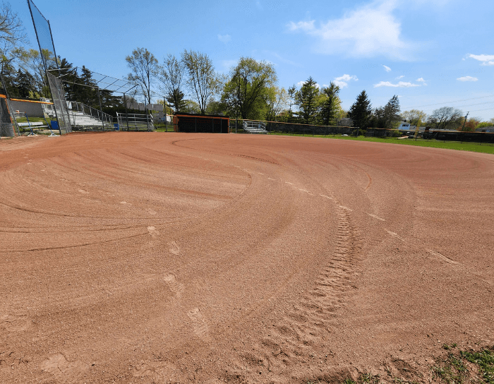An empty baseball field with a dugout in the background