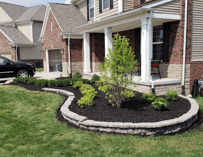 A black truck is parked in front of a brick house