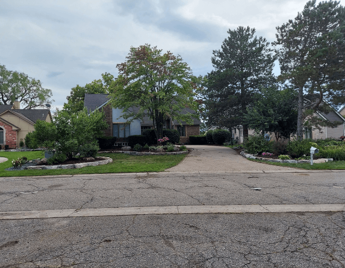 A driveway leading to a house in a residential neighborhood