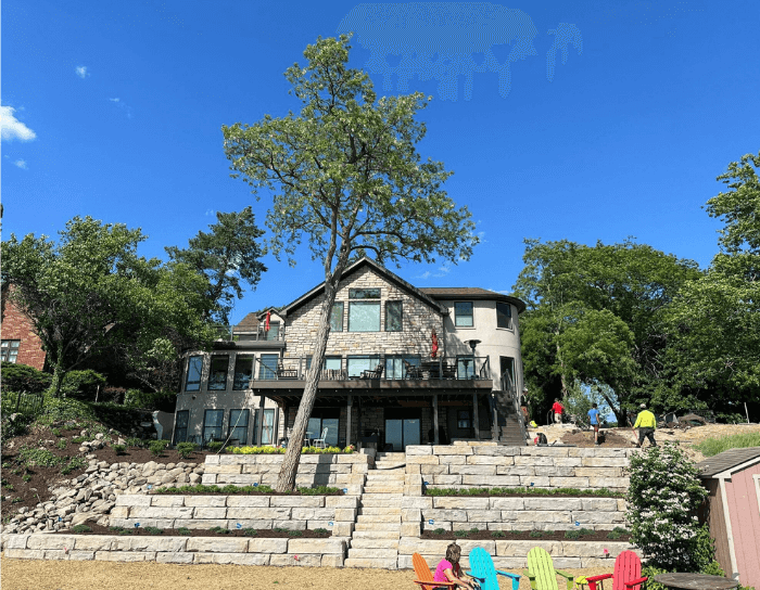 A large house sits on the shore of a lake