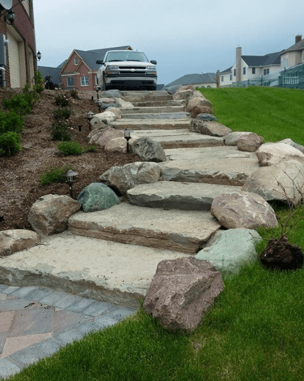 A car is parked on the side of a stone walkway