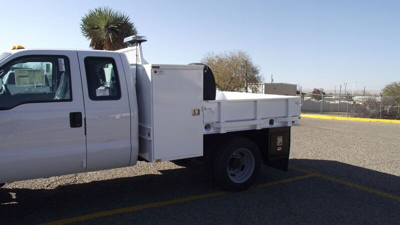 White work truck in parking lot, sunny day.