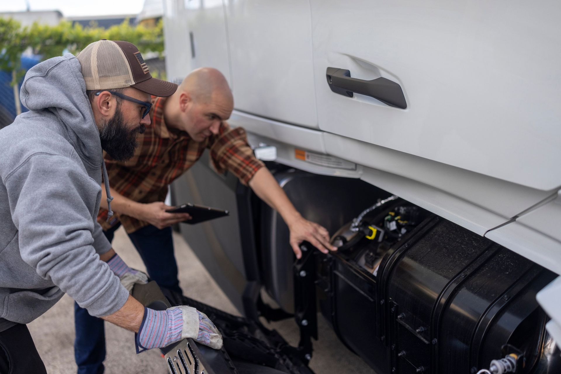 A truck driver explains to a mechanic what is wrong with the truck's engine. A truck driver explains to a mechanic what is wrong with the truck's engine.